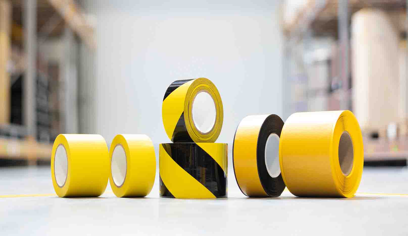 various floor marking tape rolls side by side on the floor of a storage hall