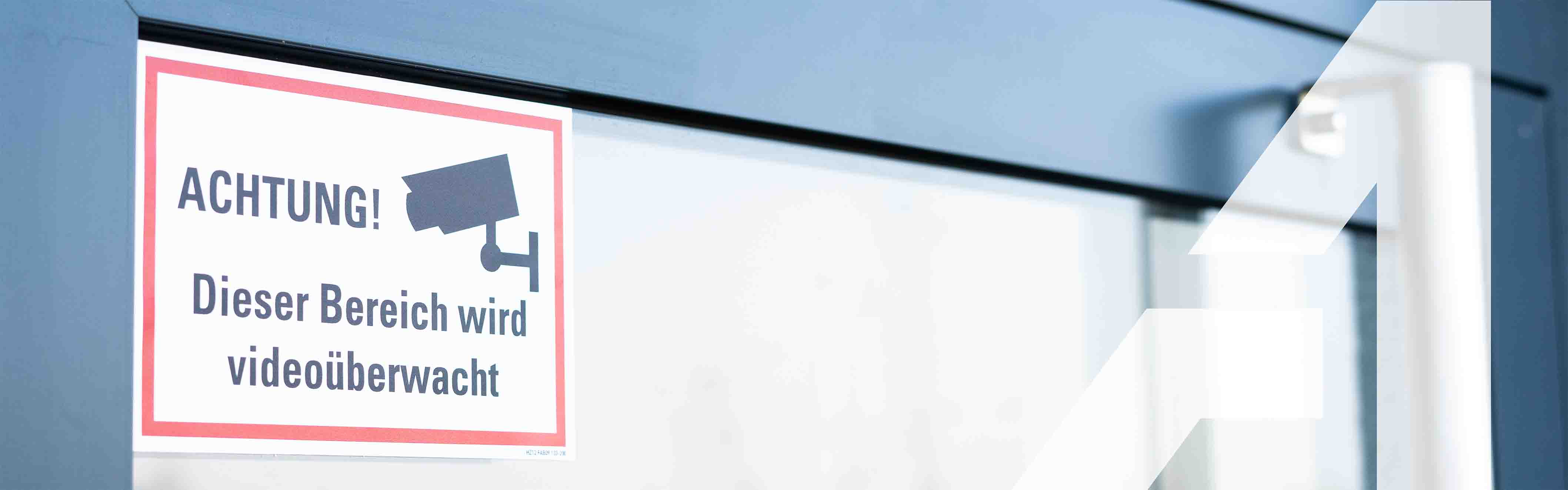 Hinweisschild am Fenster mit der Aufschrift Achtung! Dieser Bereich wird videoüberwacht