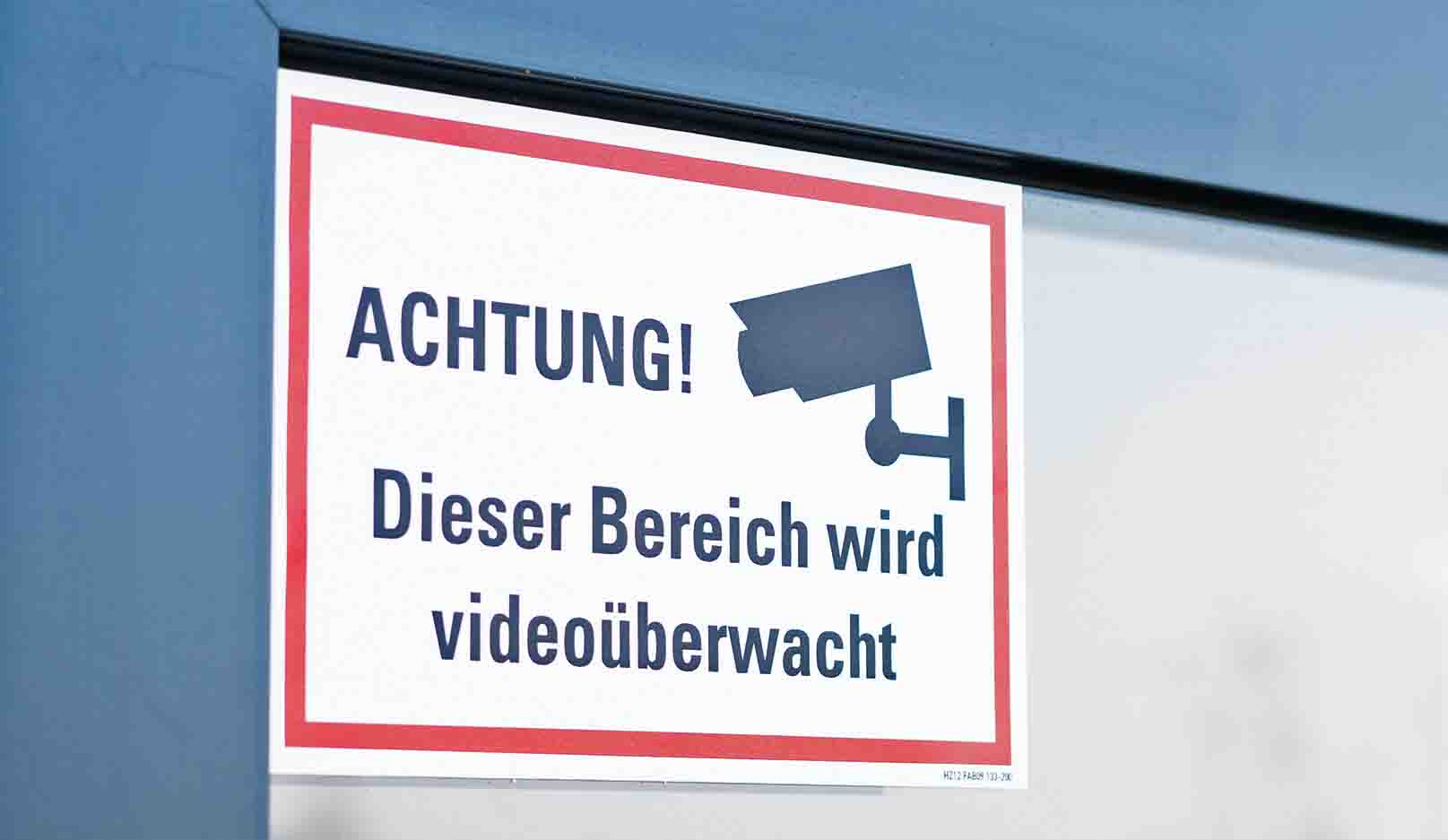 Schild am Fenster mit der Aufschrift Achtung! Dieser Bereich wird videoüberwacht